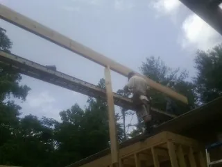 Carpenter setting a ridge beam over a new addition frame — Ice Dam Removal by Roofing Brothers in Gibbstown